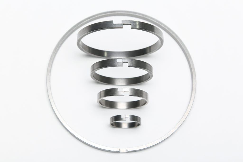 Step gap piston plunger wear rings for die casting machines